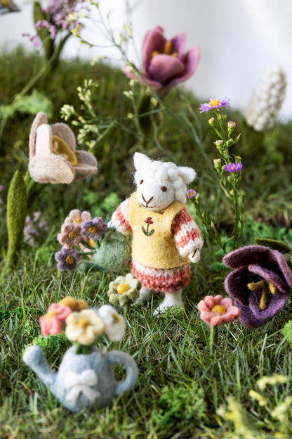 Kleines Schäfchenmädchen mit Gießkanne