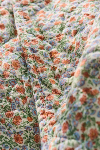 Quilt mit hellblauen und orangen Blumen