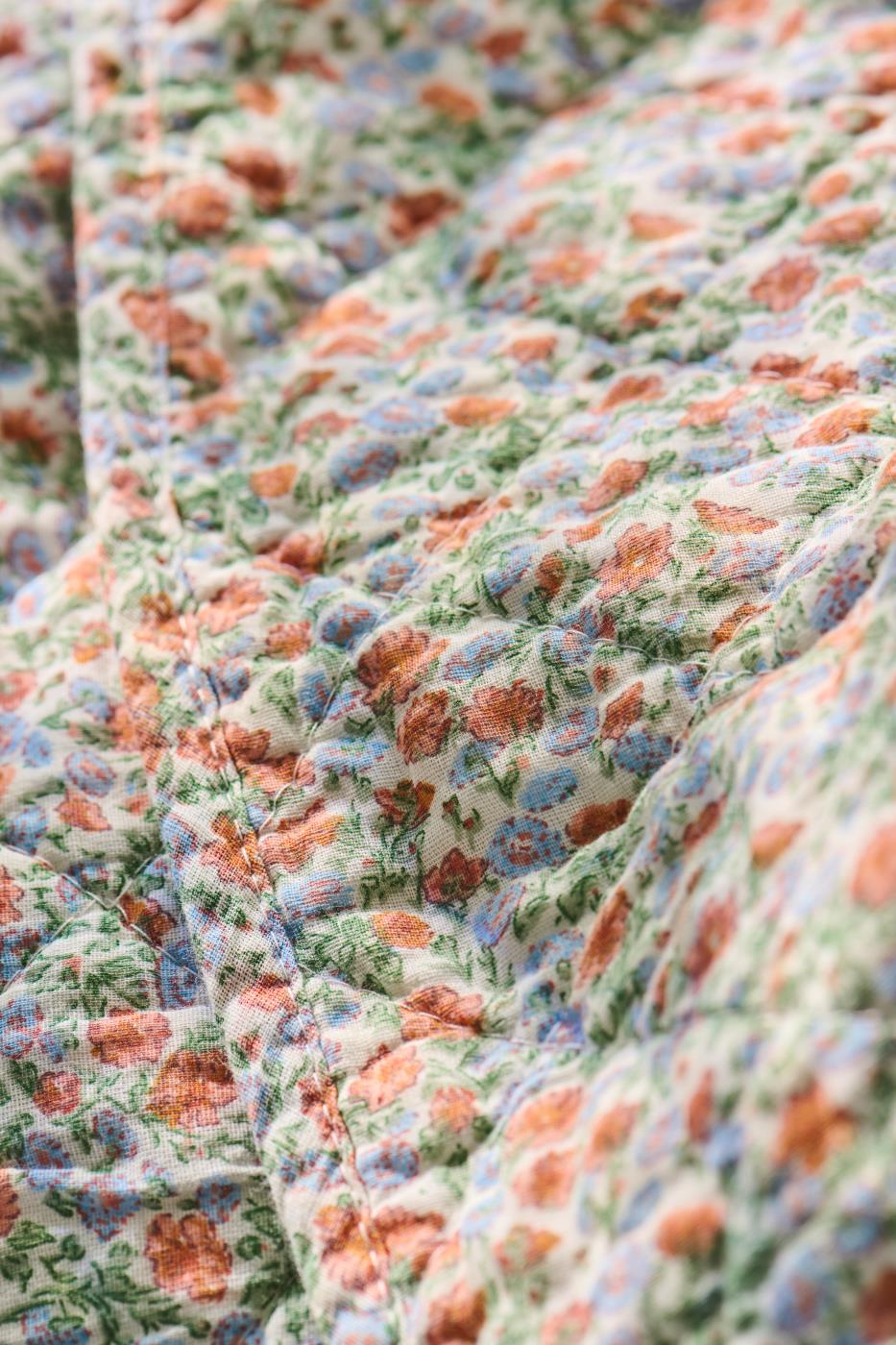 Quilt mit hellblauen und orangen Blumen