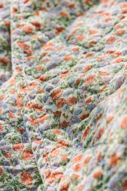 Quilt mit hellblauen und orangen Blumen