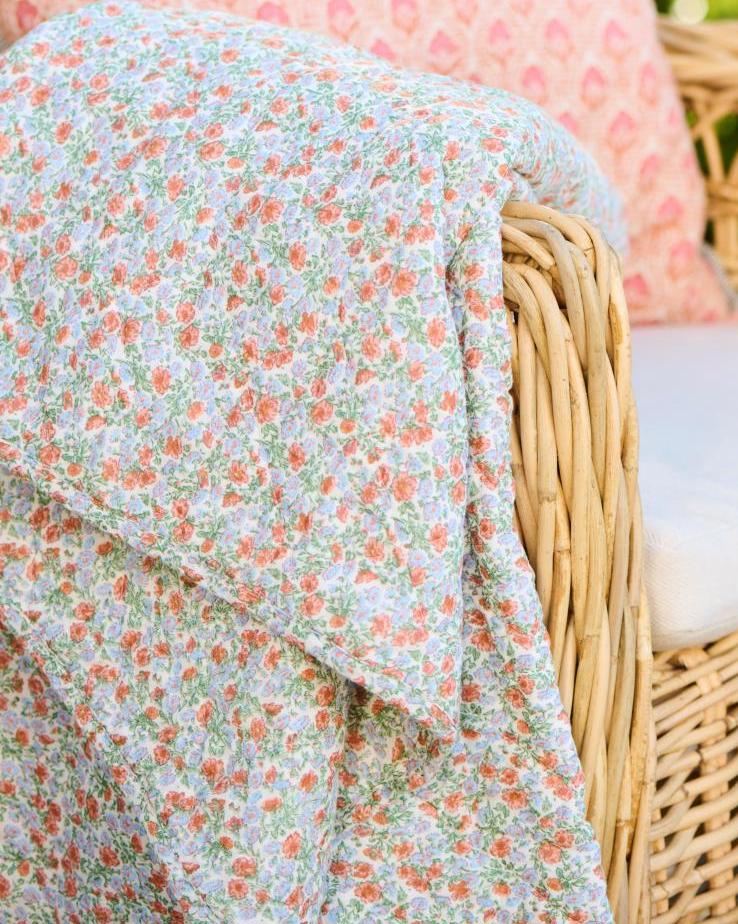 Quilt mit hellblauen und orangen Blumen