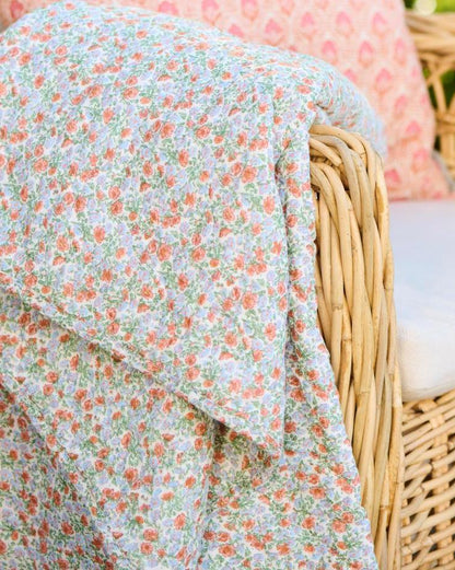 Quilt mit hellblauen und orangen Blumen
